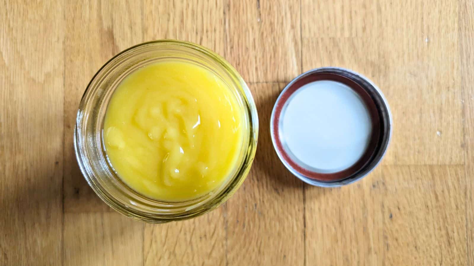 Image shows a spoon pulling lemon curd from a jar.