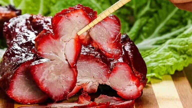 Sliced char siu pork with lettuce leaves.