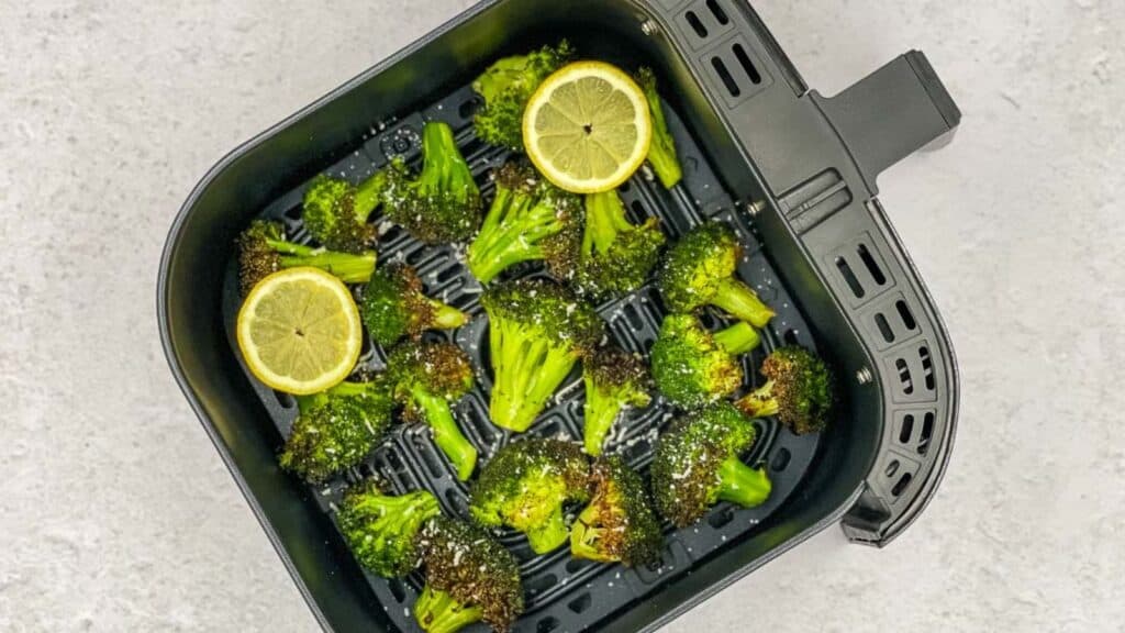 A pan with broccoli and lemon slices in it.