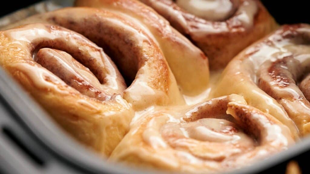 Cinnamon rolls in a pan with icing.