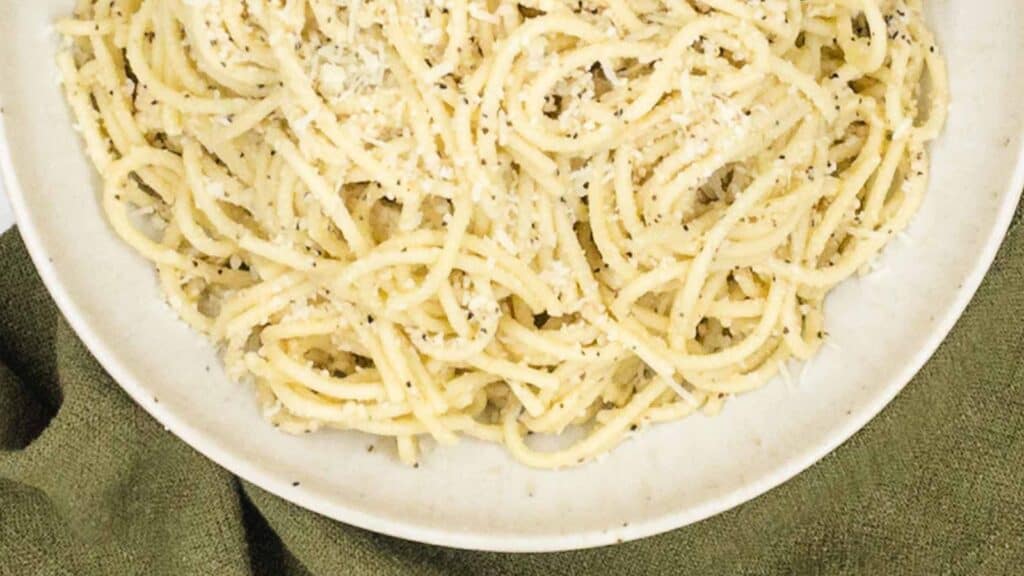 A plate of pasta with parmesan cheese on it.