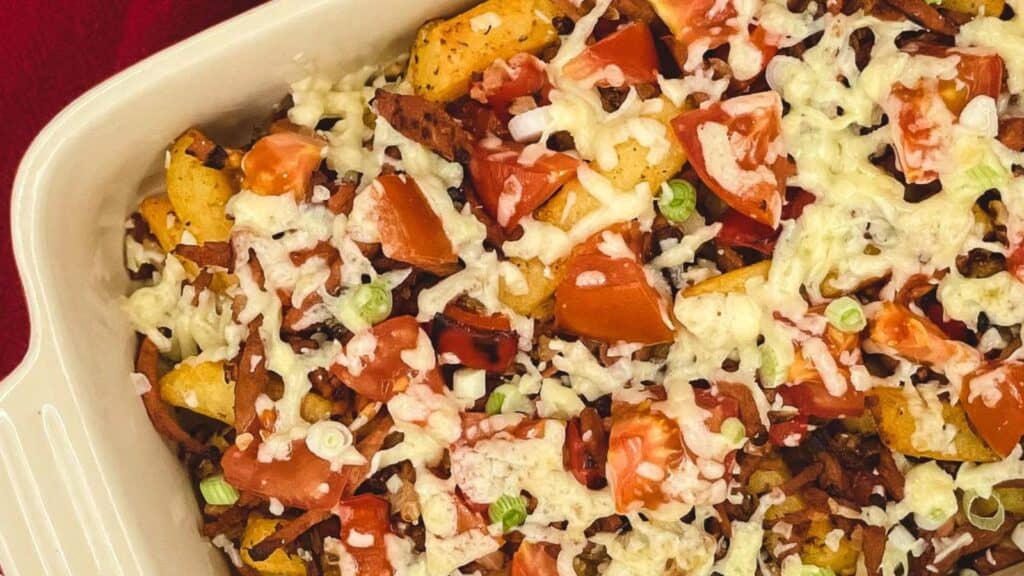 A casserole dish filled with tomatoes and cheese.