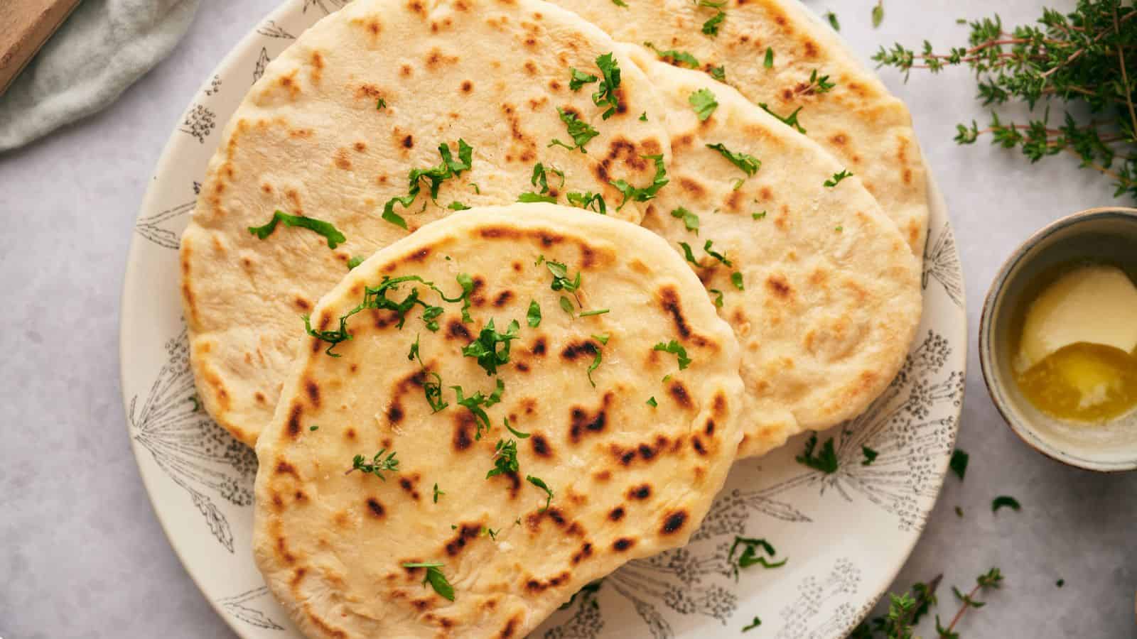 Three freshly cooked flatbreads on a plate.