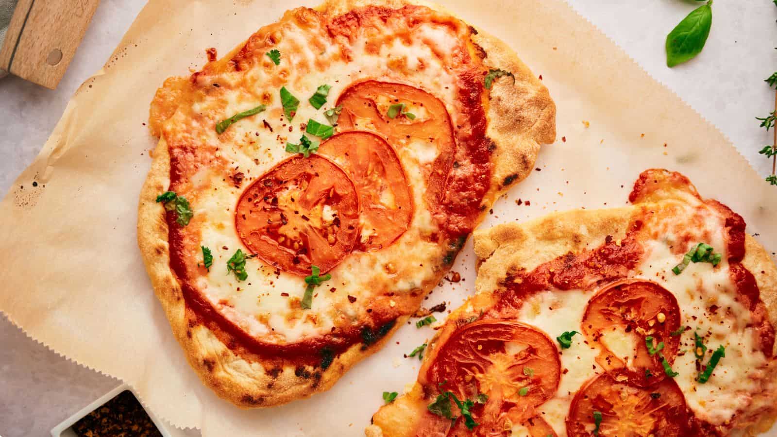 Greek pizza, sliced on a board.