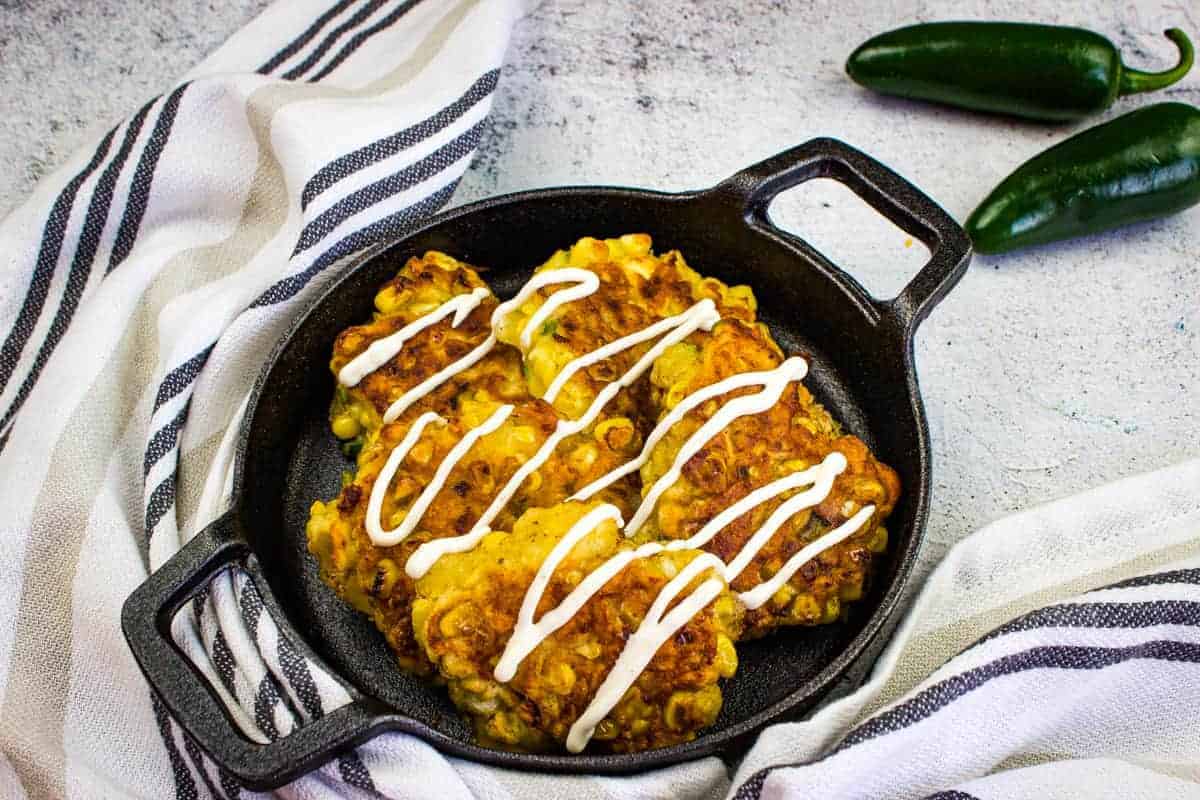 Corn fritters in a black cast iron pan.