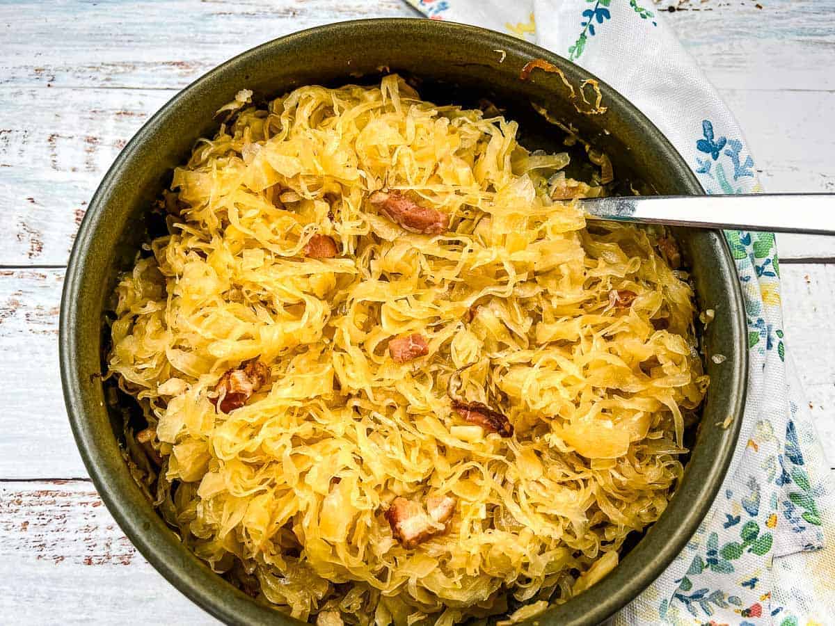 Sauerkraut in a serving dish with a spoon.