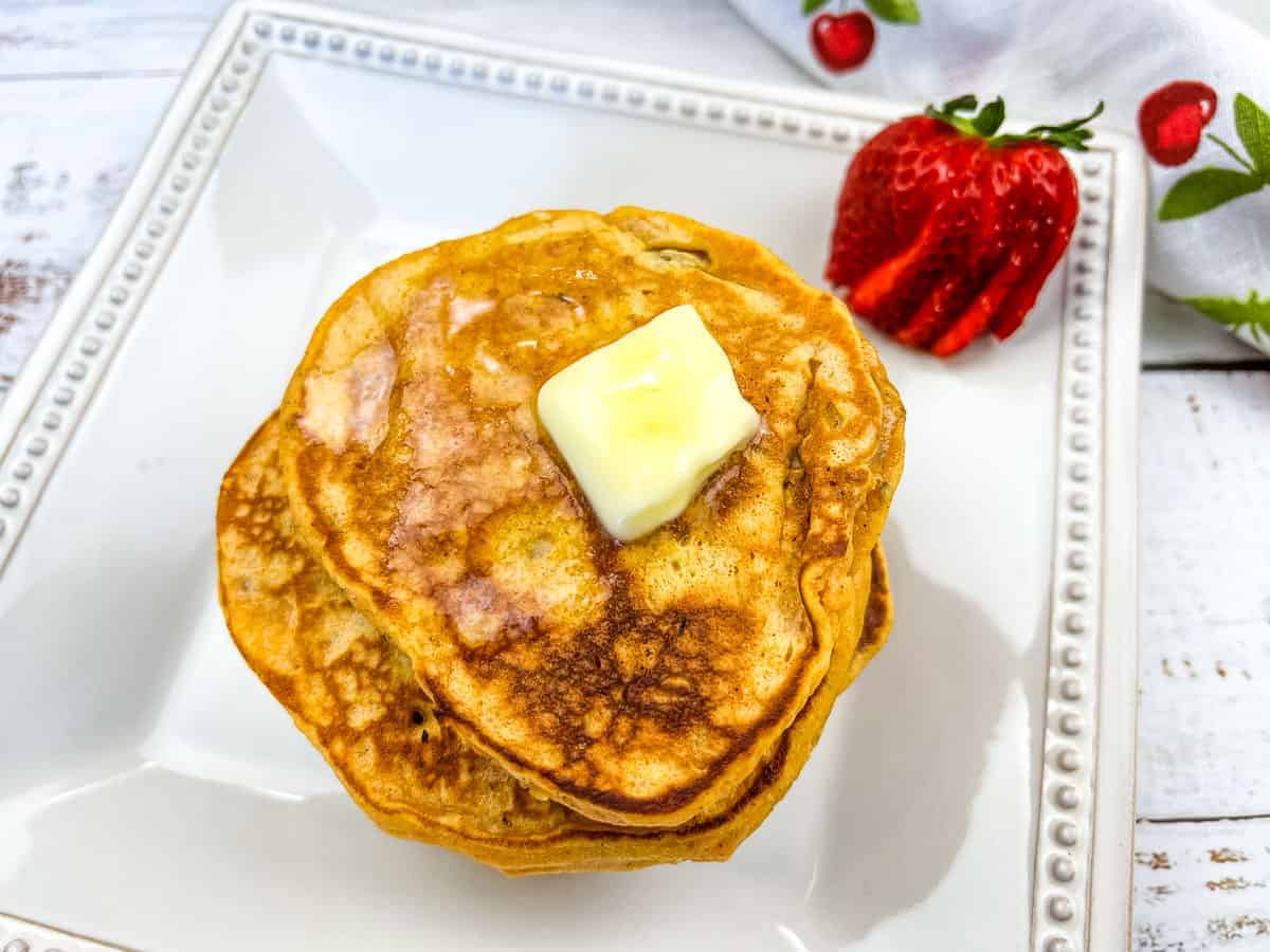 A stack of Sweet Potato Pancakes with a berry.