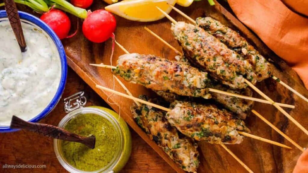 Kebabs on skewers with tzatziki sauce.