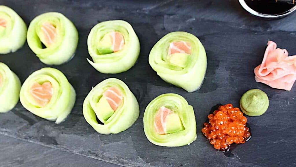 Cucumber Rolls on a black board.