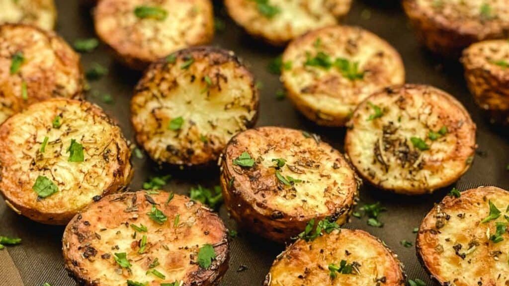 Roasted potatoes with parsley on a baking sheet.