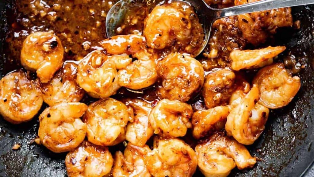 Fried shrimp in a skillet with a spoon.