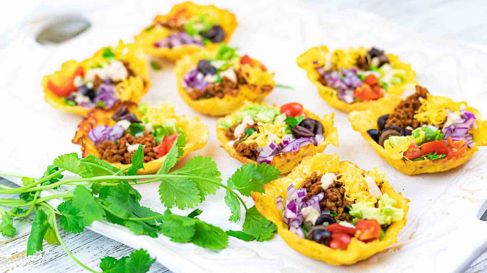 Easy Crunchy Keto Taco Cups on a white board with cilantro. 