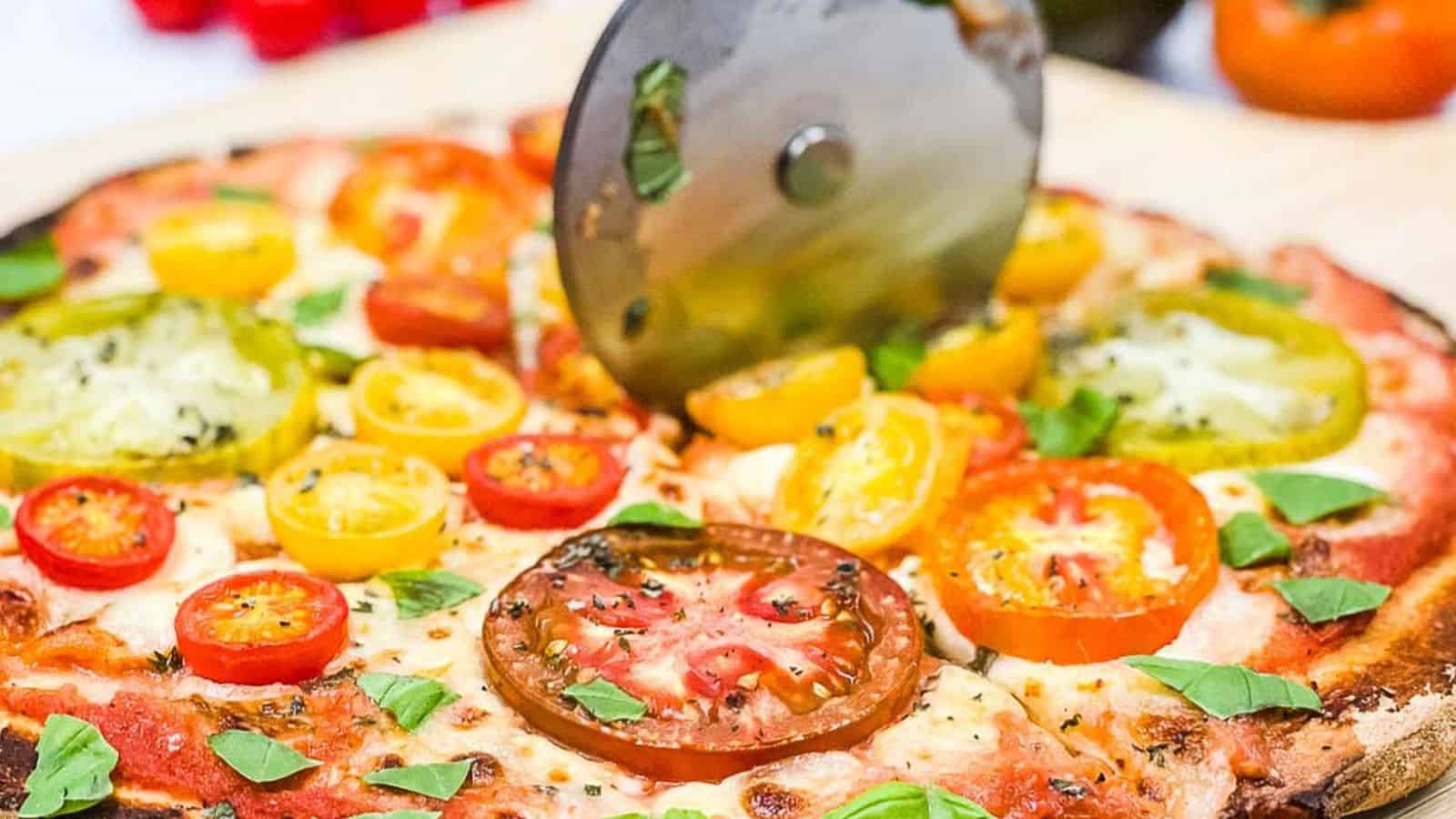 Someone slicing a pizza with a pizza cutter.