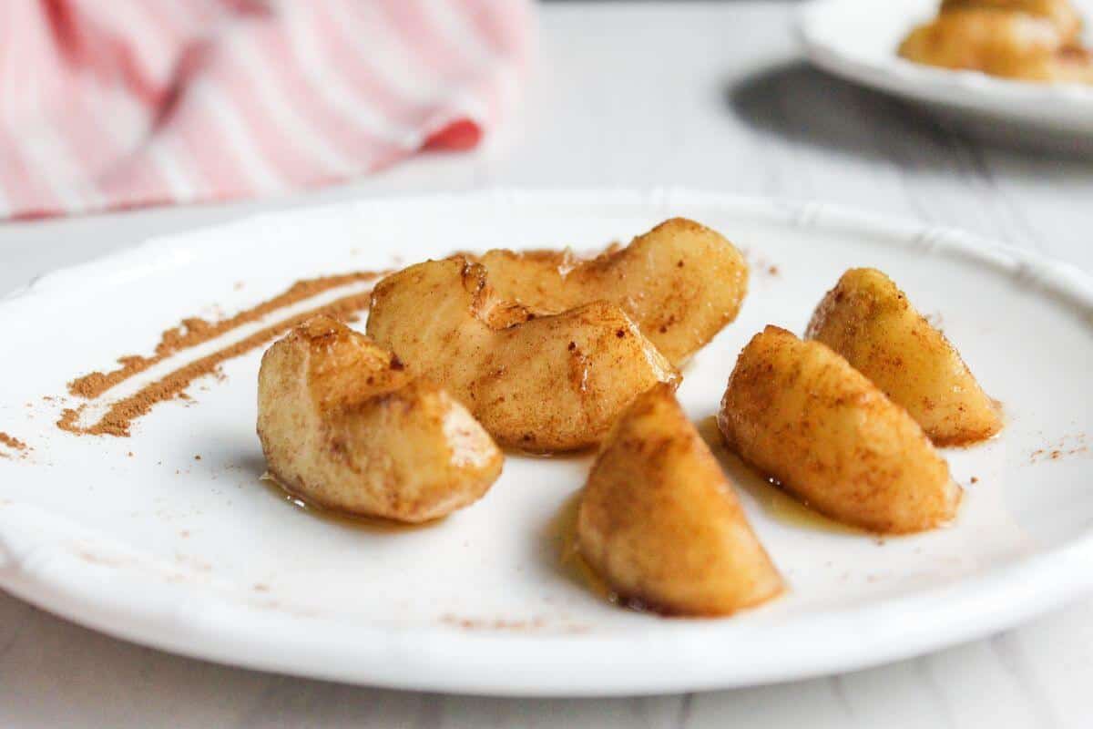 Cinnamon apple slices on a white plate.