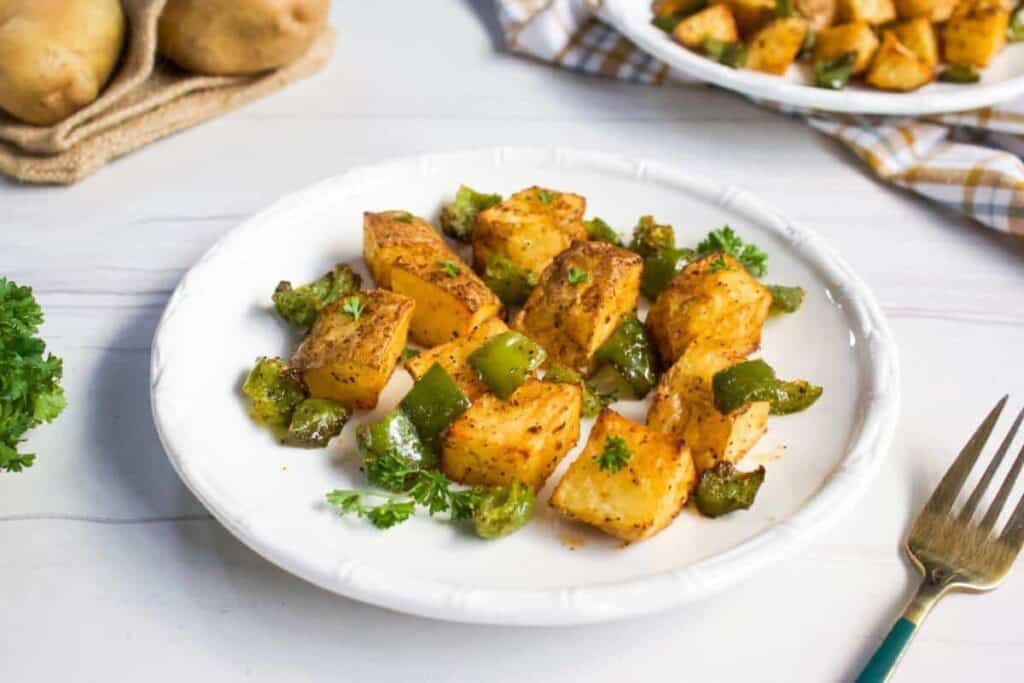 Potatoes and peppers on a plate with a fork.