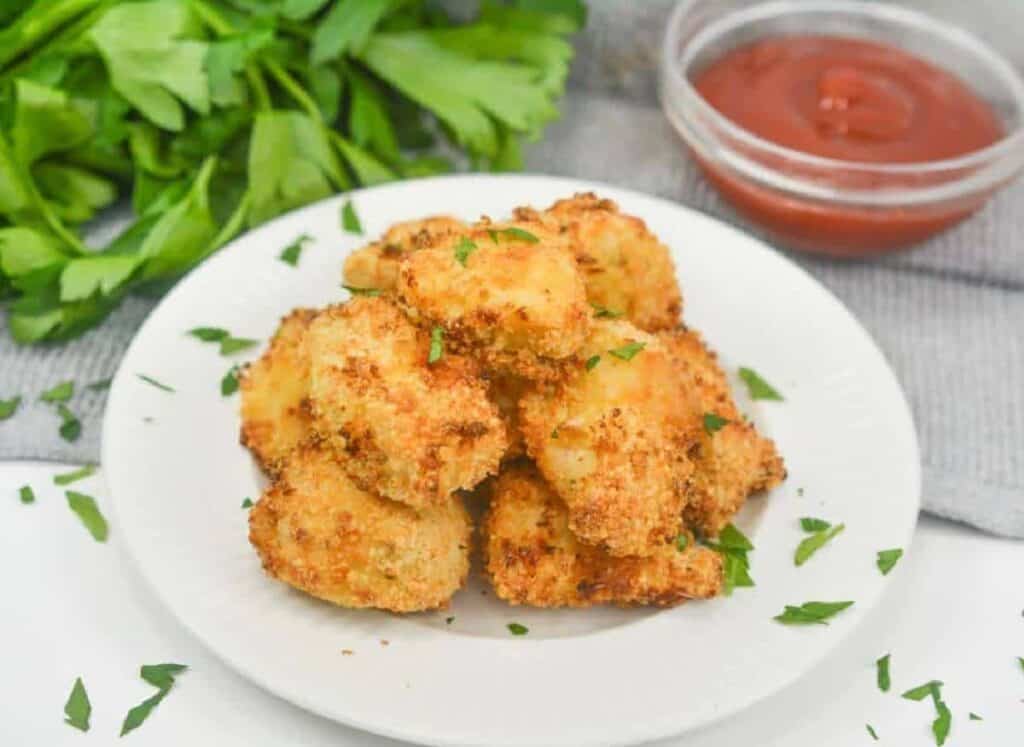 Delicious fried chicken nuggets served on a white plate, perfect for a satisfying lunch break.