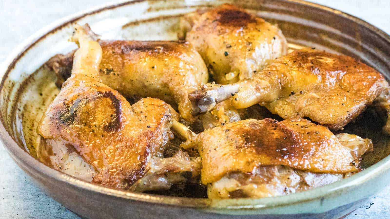 Overhead shot of a confit duck leg with orange sauce and star anise pods.