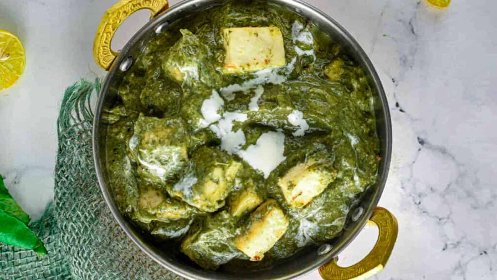 Overhead shot of palak paneer in a metal serving dish.