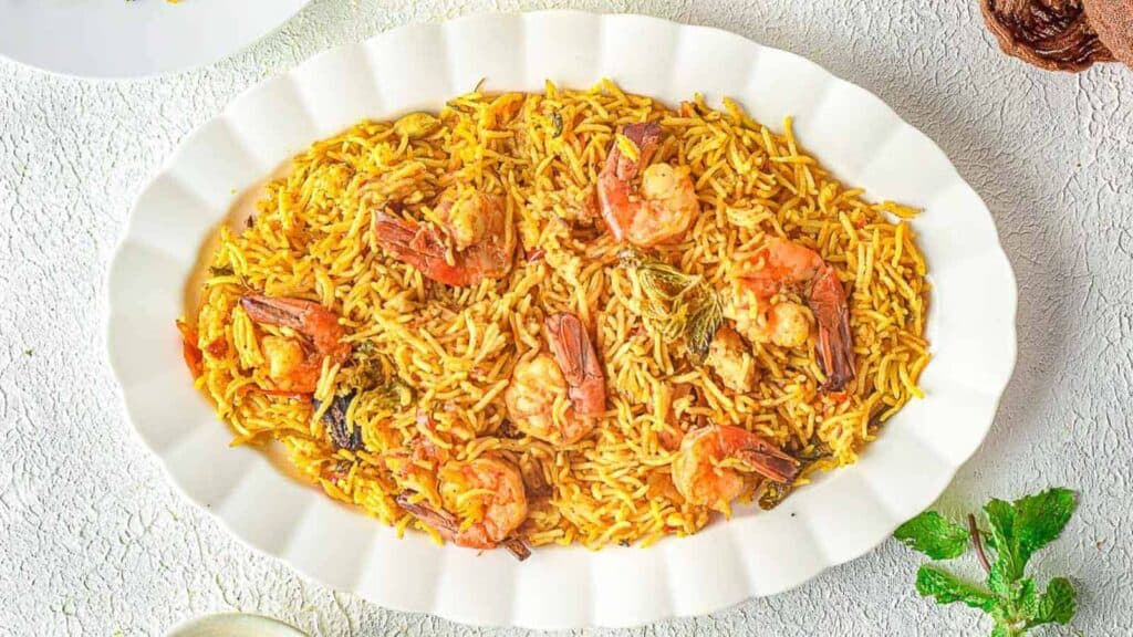 A plate of rice and shrimp on a table.