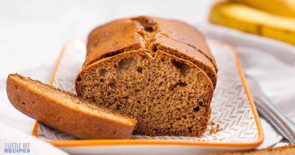 A slice of banana bread on an orange plate.