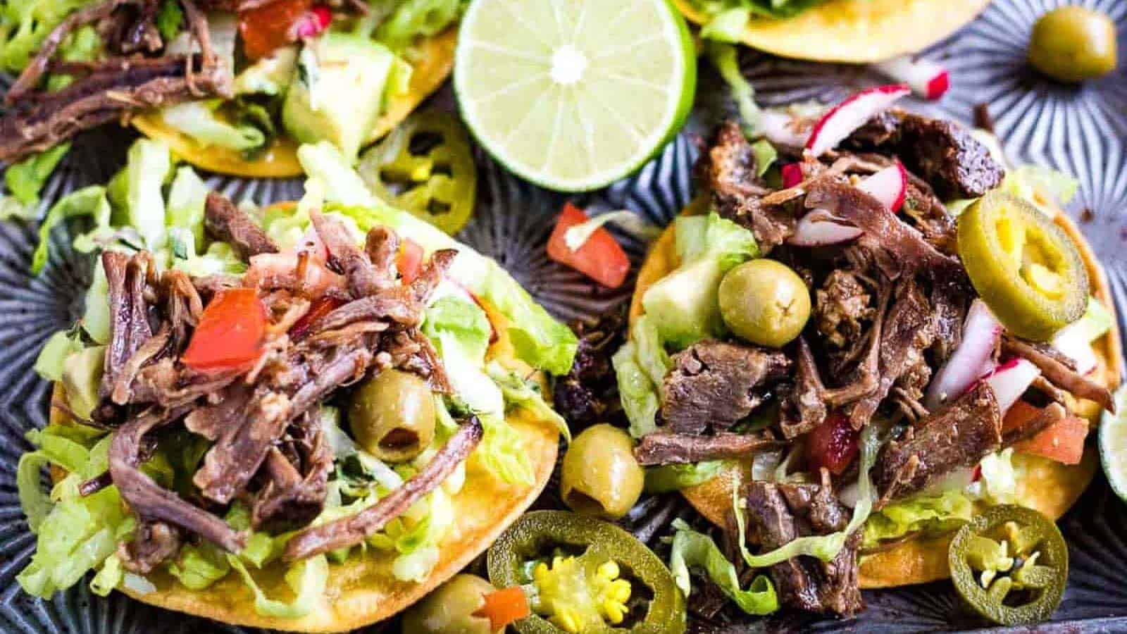 Low angle shot of mini tostadas with salpicon de res or shredded beef salad on top.