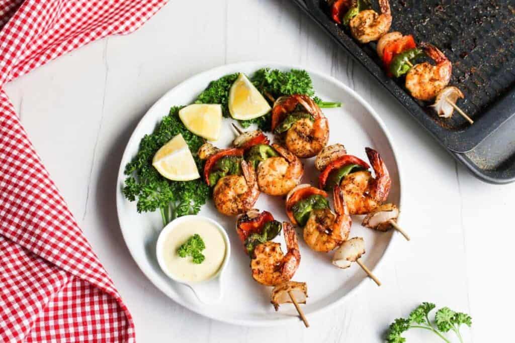 Shrimp skewers served alongside refreshing lemon wedges, a tantalizing lunch idea worth taking a break for.