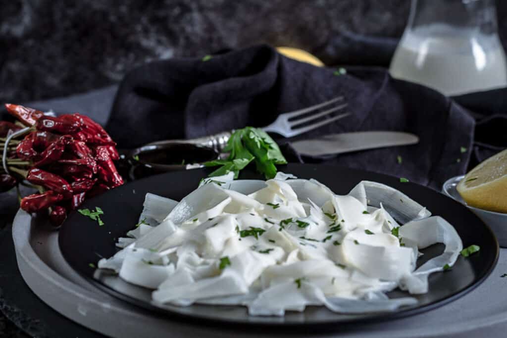 A plate of white pasta with parsley.