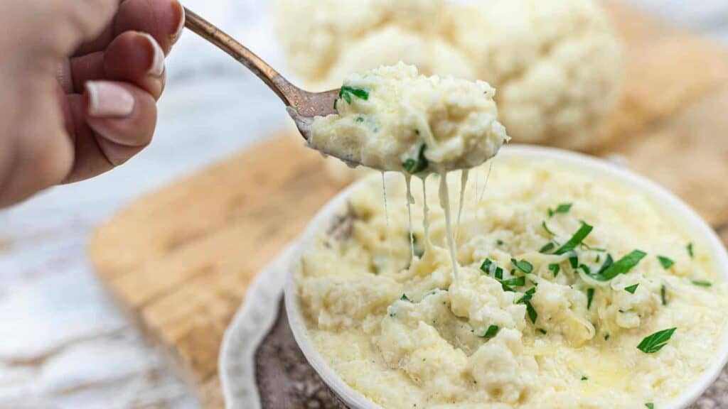 Cheesy Cauliflower Rice on a spoon with melted cheese strikes.