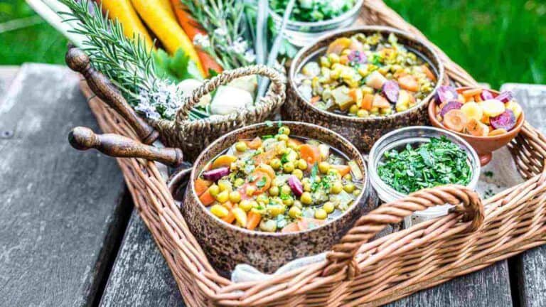 A wicker basket full of food on a wooden table.