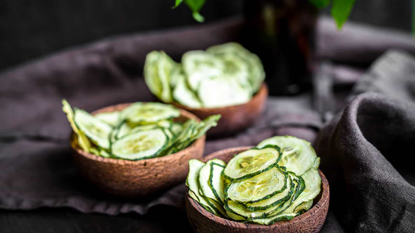 Cucumber slices inside brown bowls.