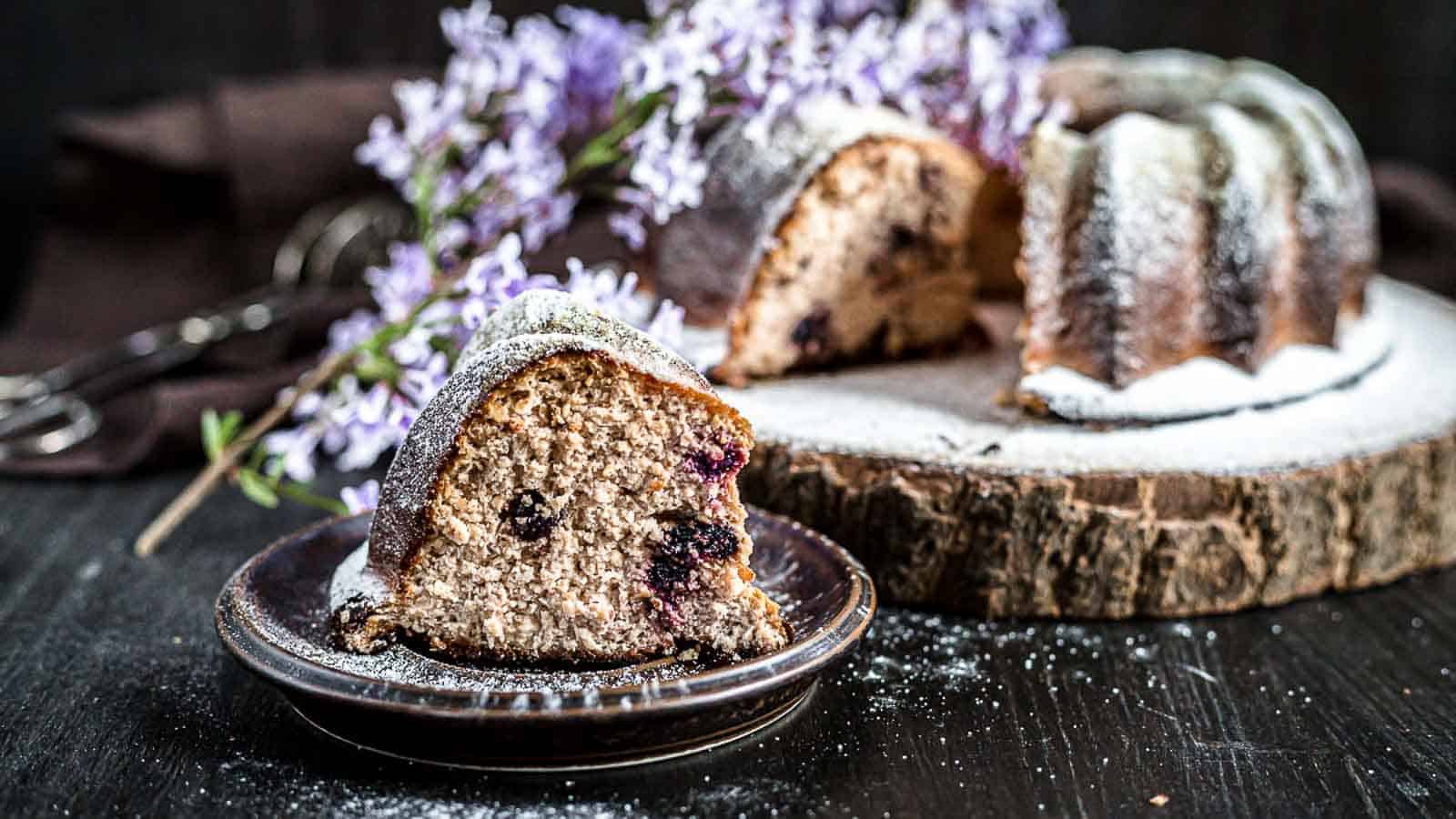 Farmers Cheesecake Keto Bundt Cake on a plate with flowers behind. 