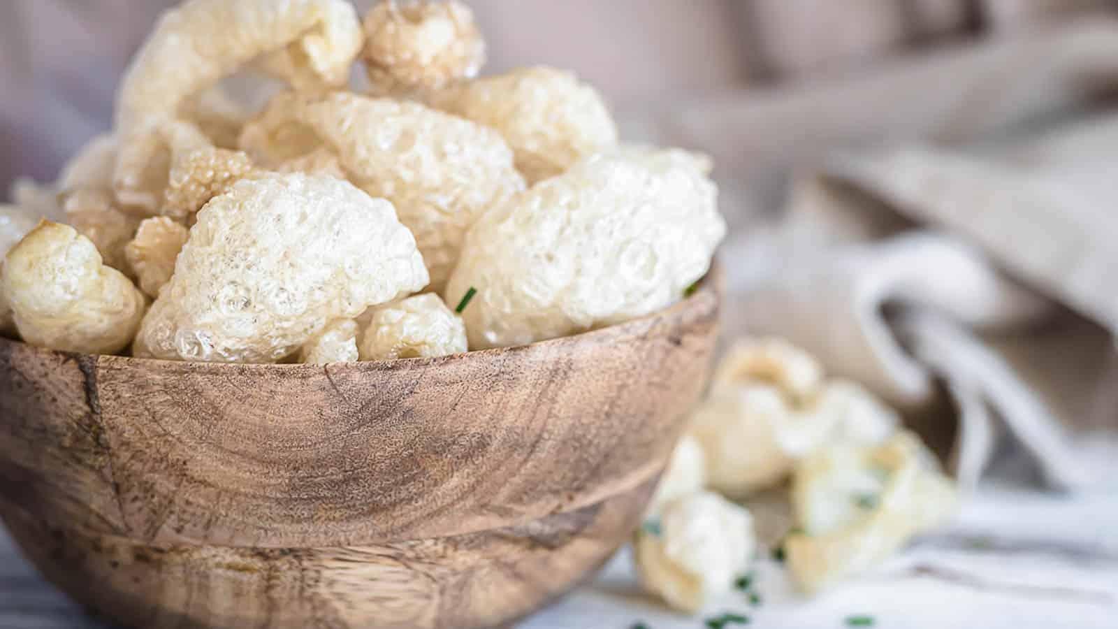 Pork rinds inside a wooden bowl.