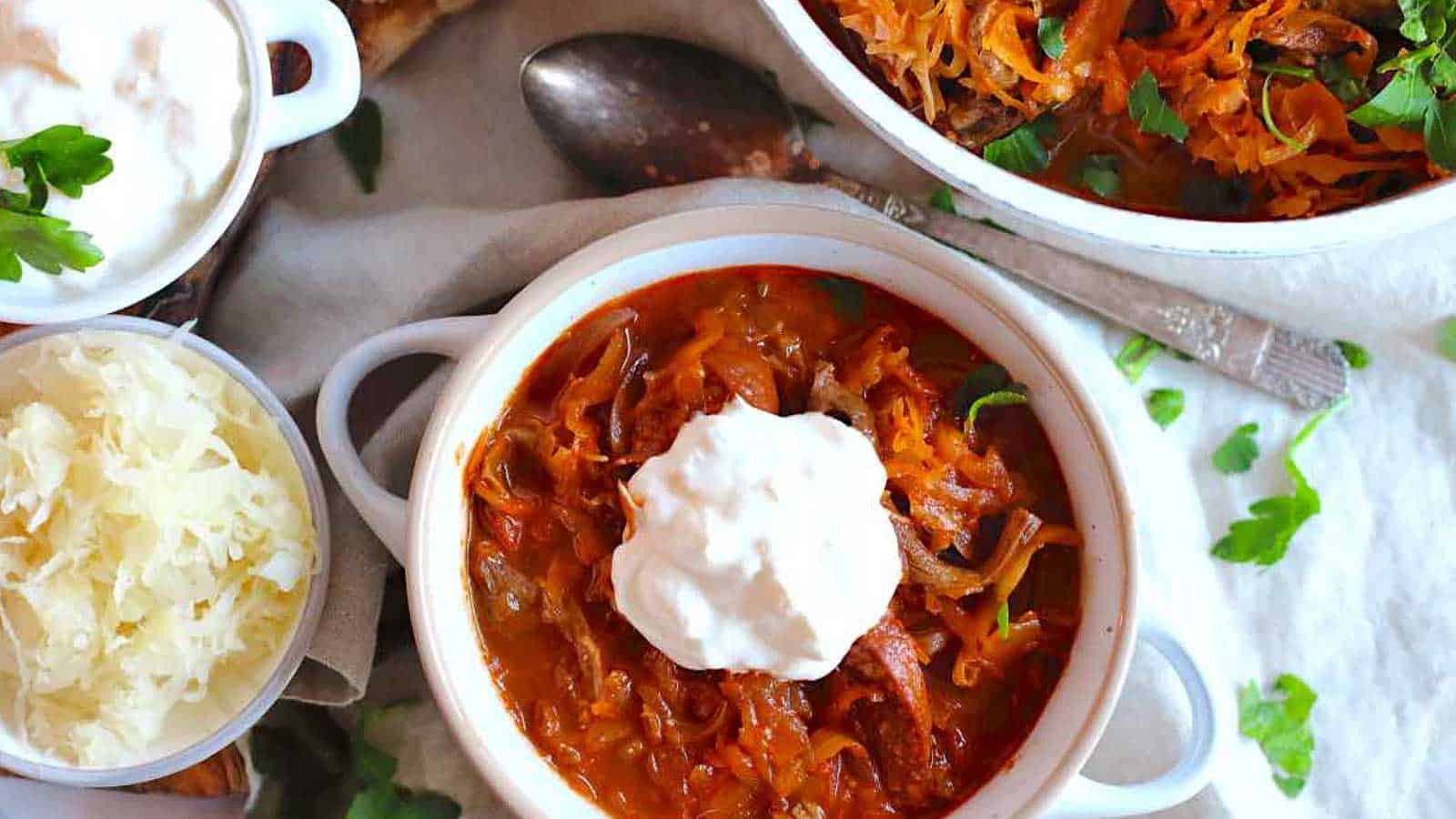 Sauerkraut Soup inside soup bowl with dollop of sour cream. 