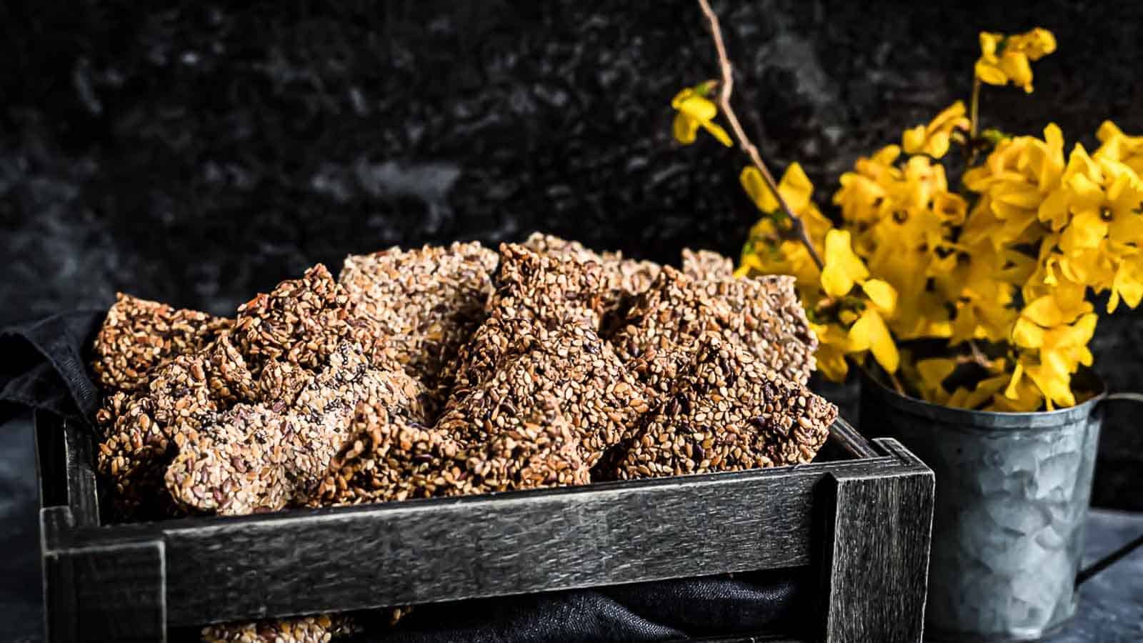 Raw Seed Keto Crackers Bread inside dark brown wooden basket. 