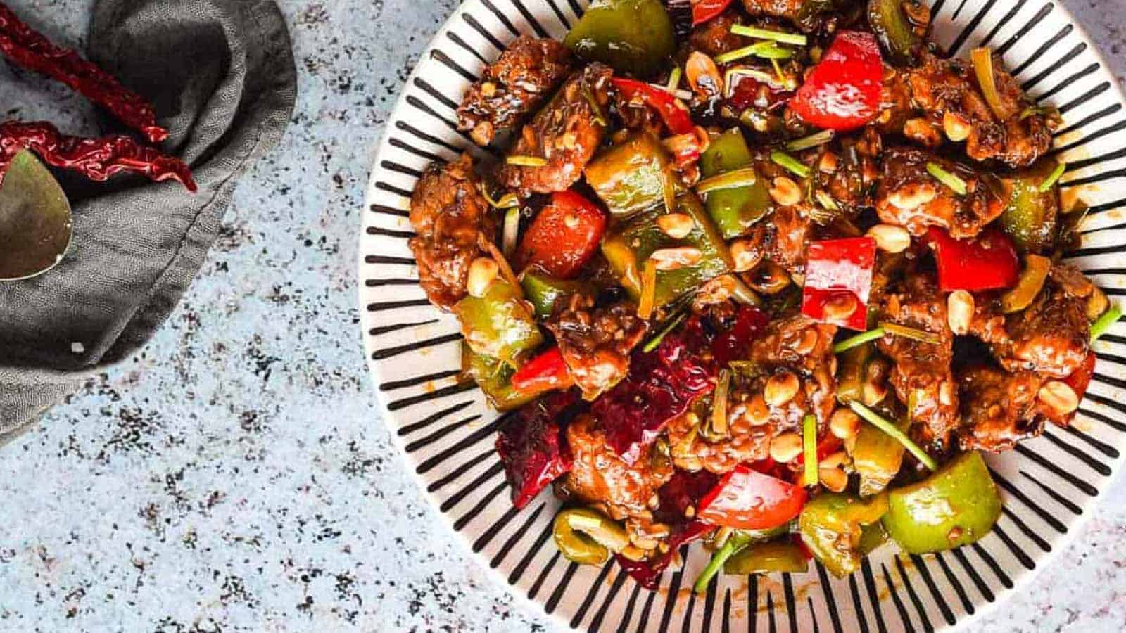 Overhead shot of a striped bowl with kung pao chicken.