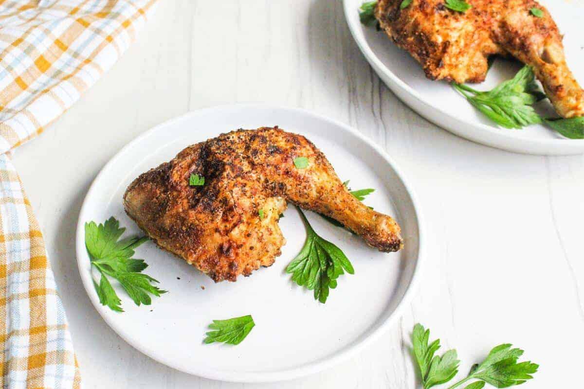 Air fried chicken leg quarters served on plates.