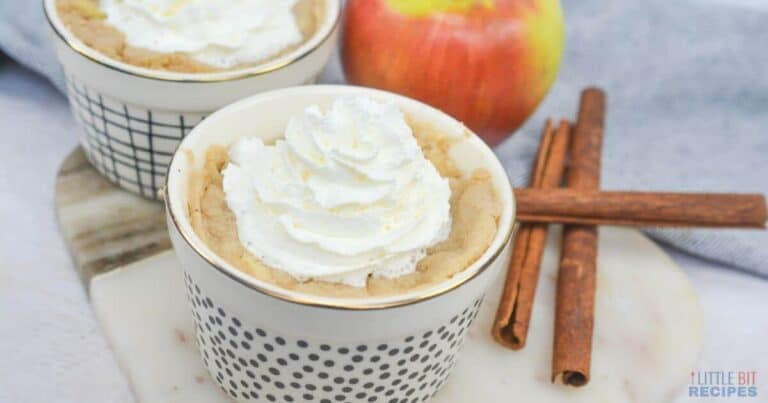 Apple mug cakes in ramekins with cinnamon sticks.