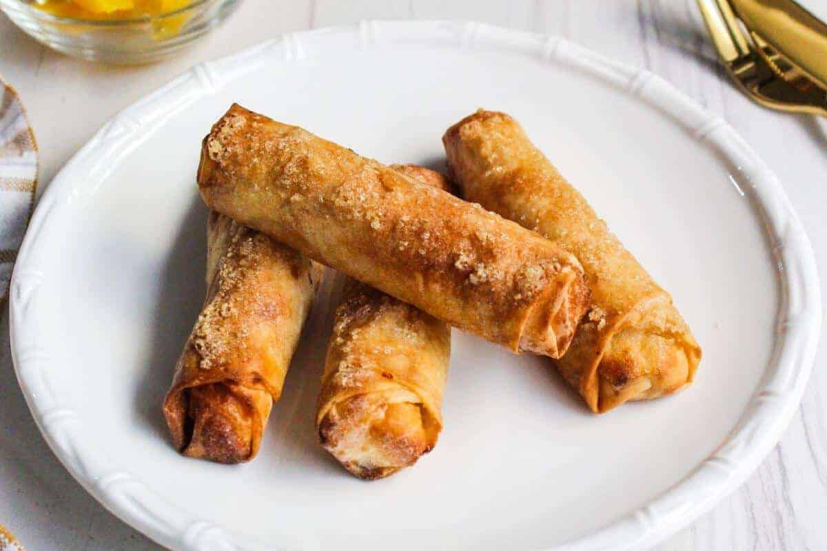 Fried Filipino banana turon lumpia on a white plate.