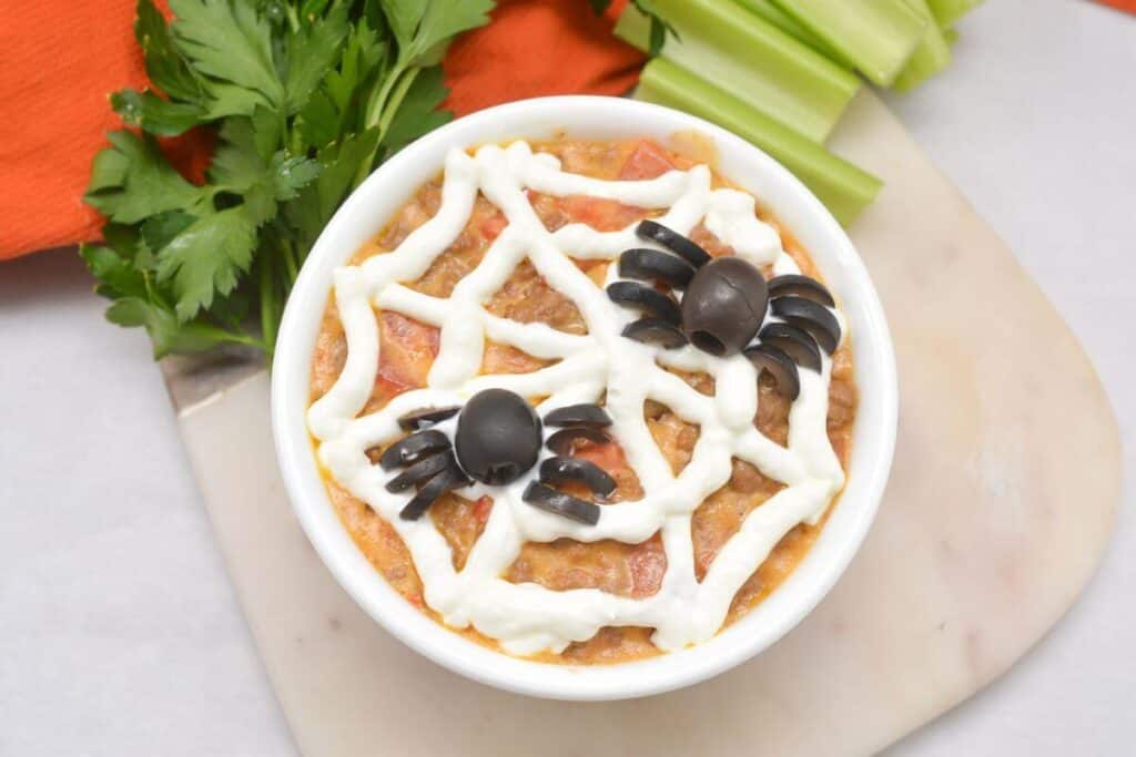 A bowl with a spider and celery on it.