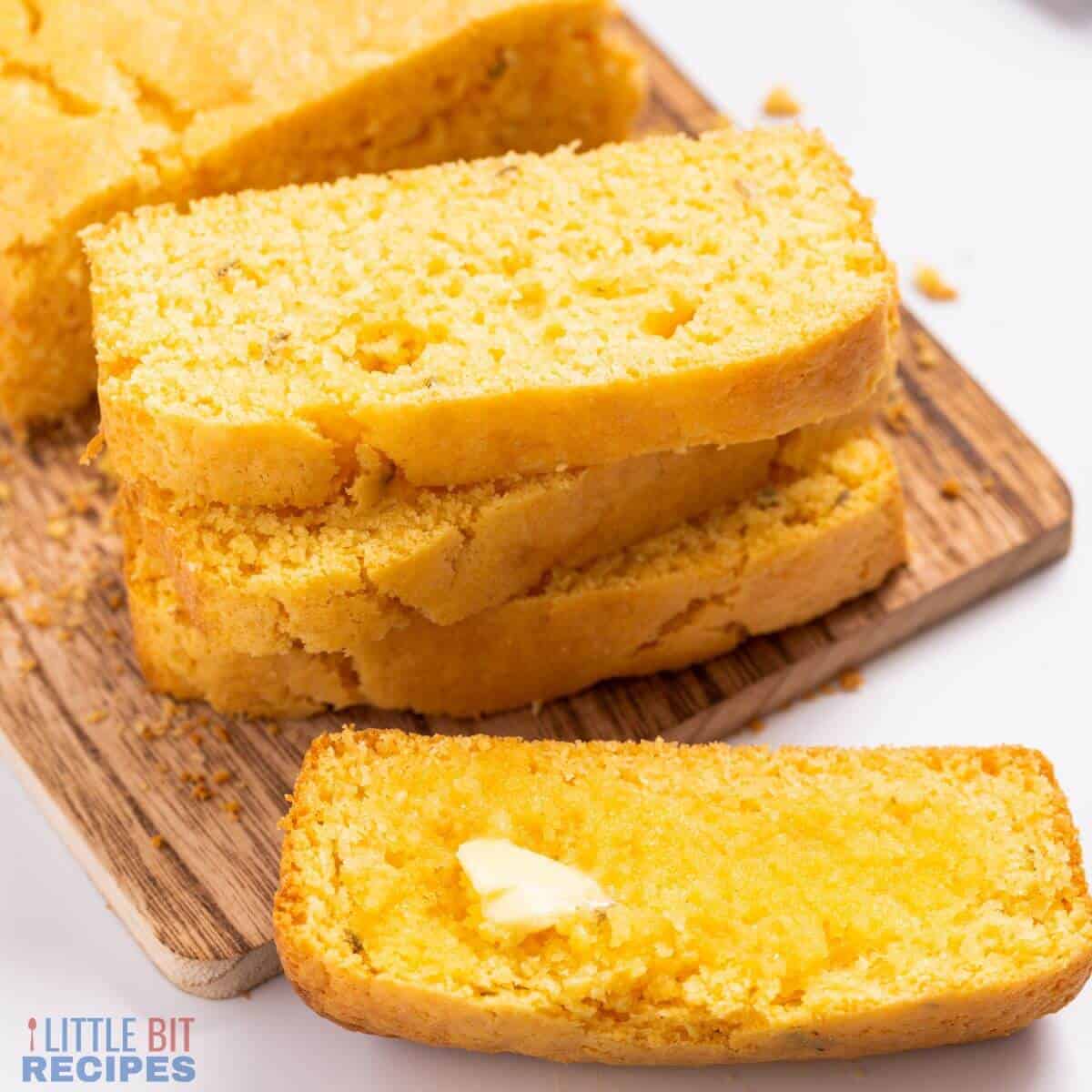 Sliced cornbread on a wood cutting board.