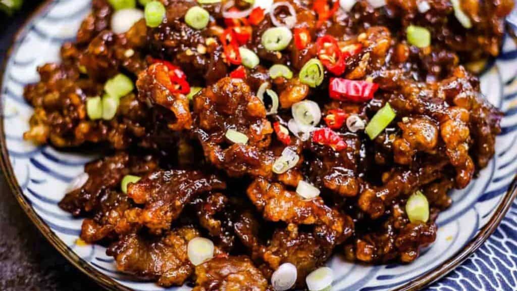 Low angle shot of crispy beef on a plate.