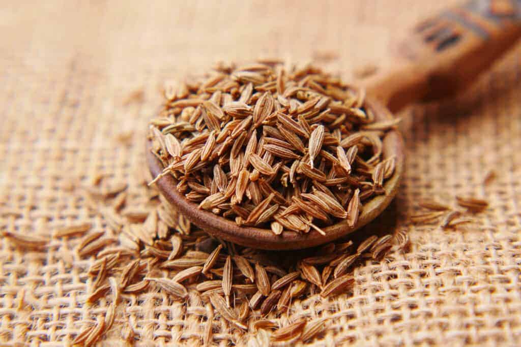 Saffron seeds on a wooden spoon.