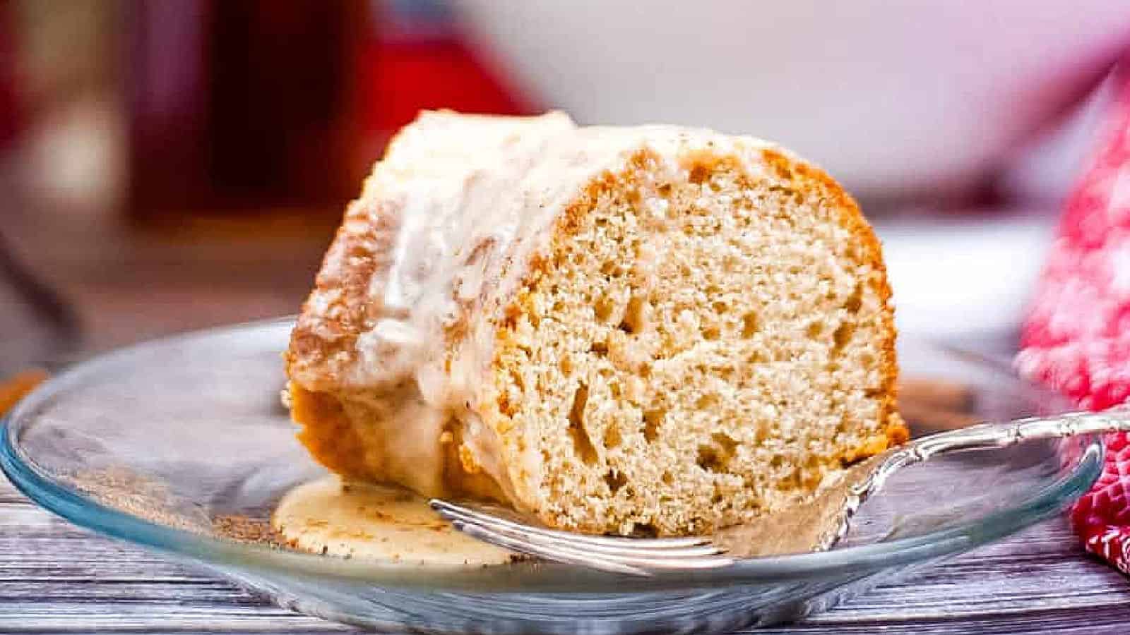 Low angle shot of a wedge of eggnog cake on a glass plate.