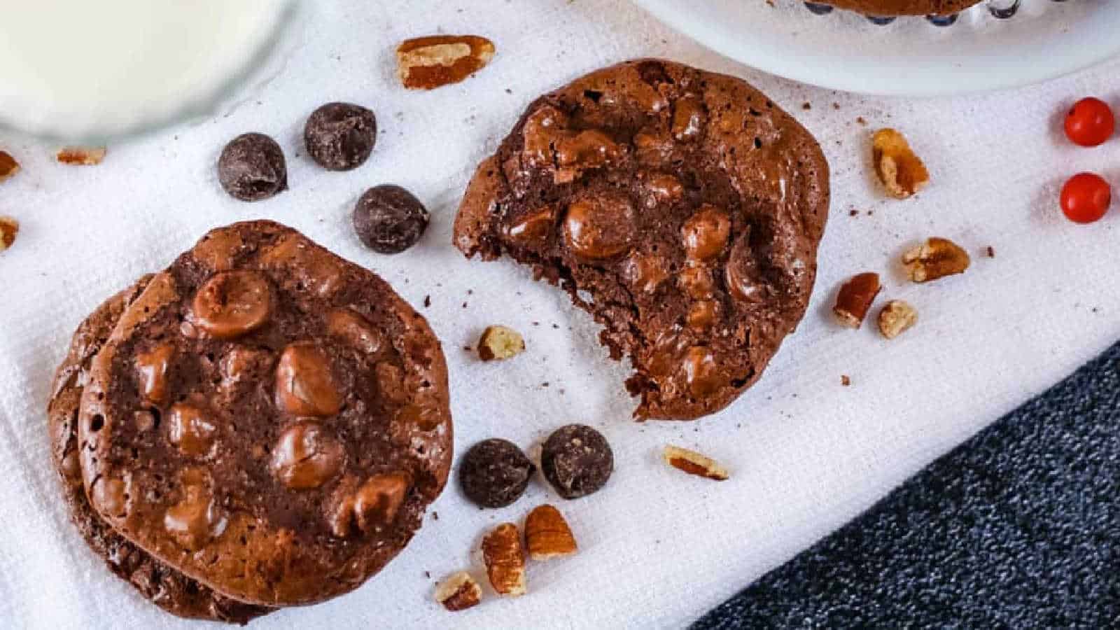 Overhead shot of cookies on a white cloth with a glass of milk.