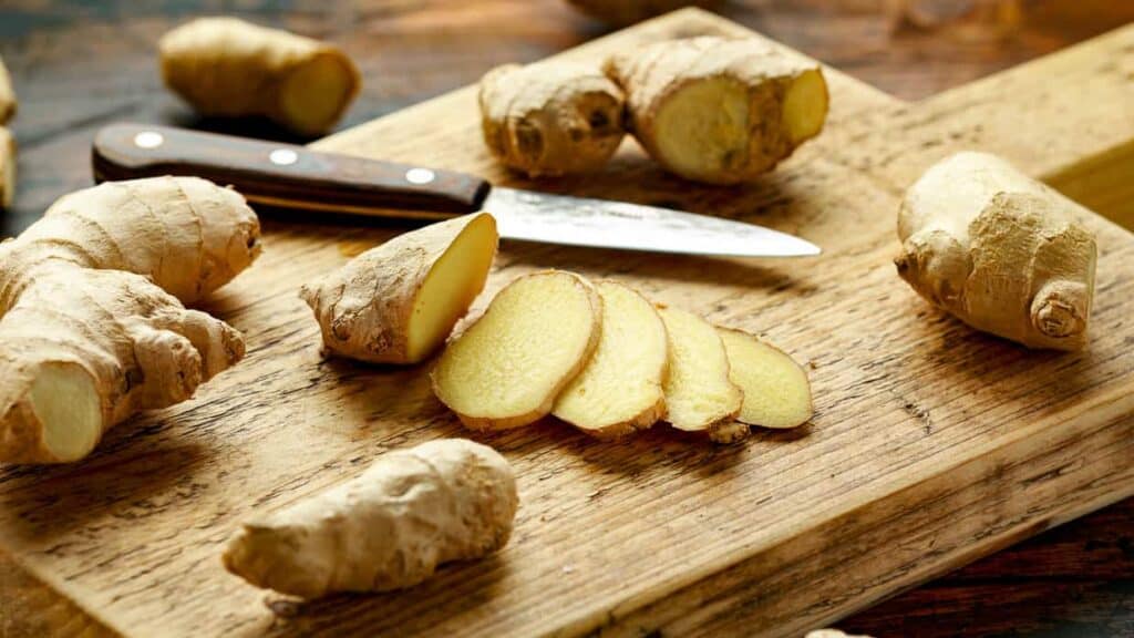 Ginger on a cutting board with a knife.