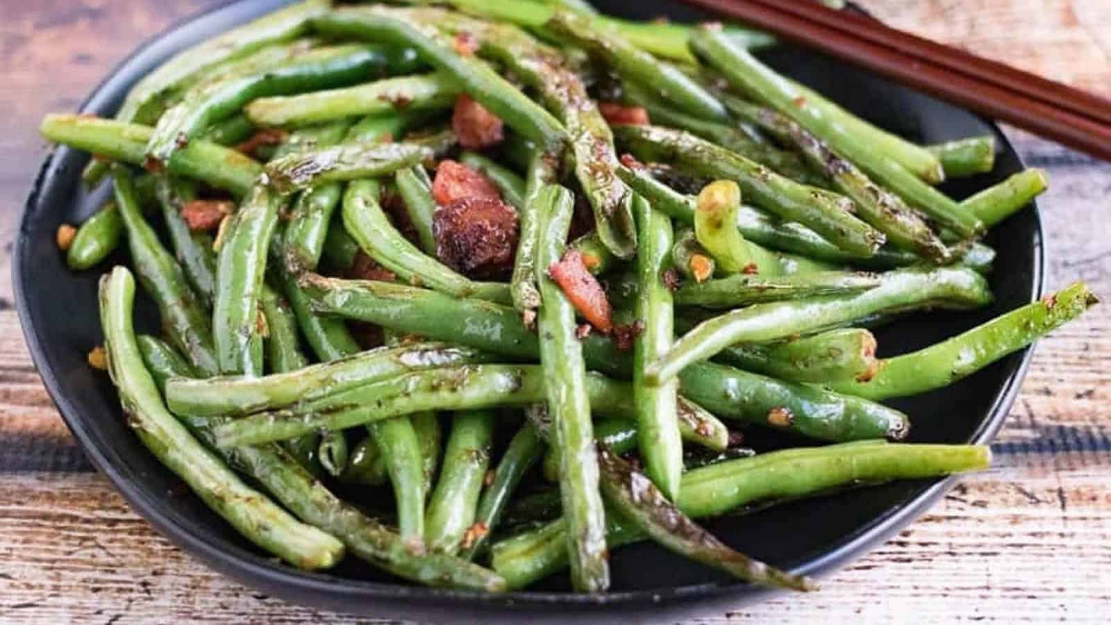 Low angle shot of a plate of dry fried green beans.