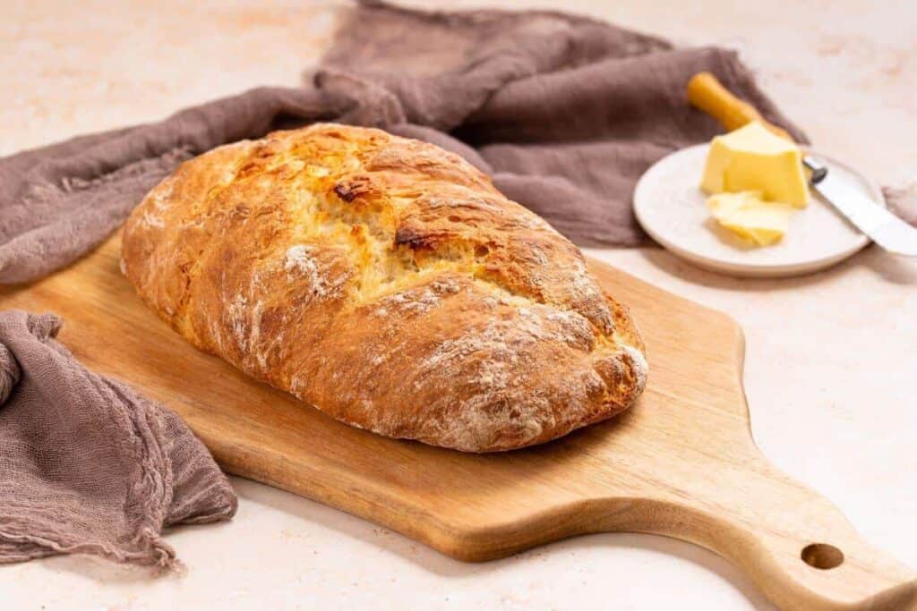 Italian artisan bread sliced on cutting board.