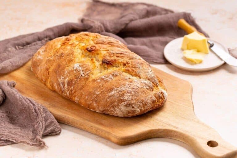 Italian artisan bread sliced on cutting board.