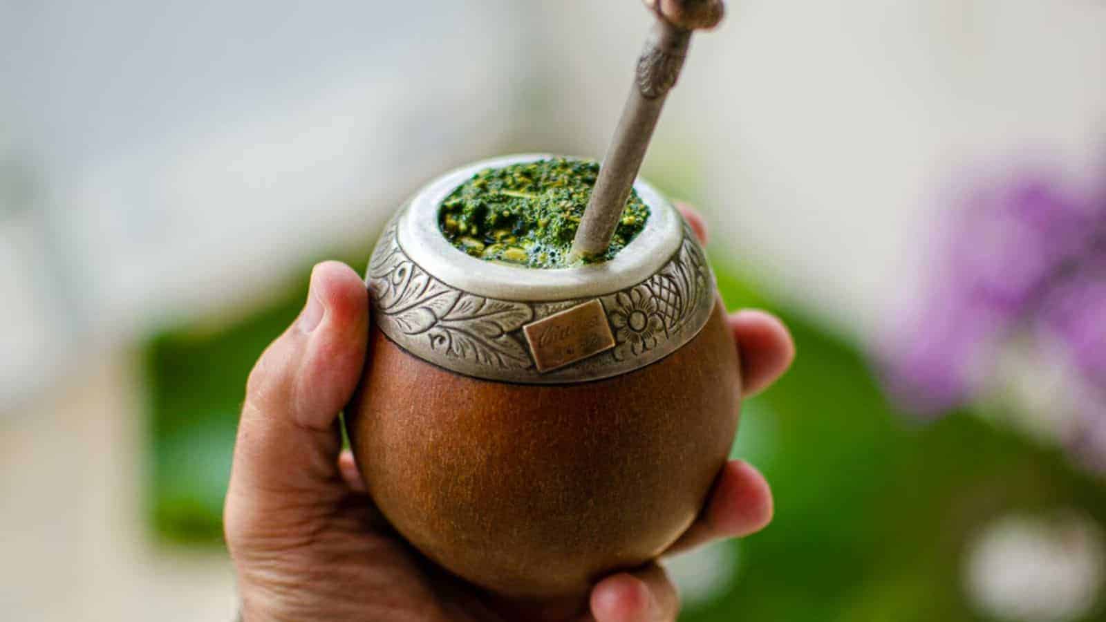 A man holding traditional yerba mate jug. 