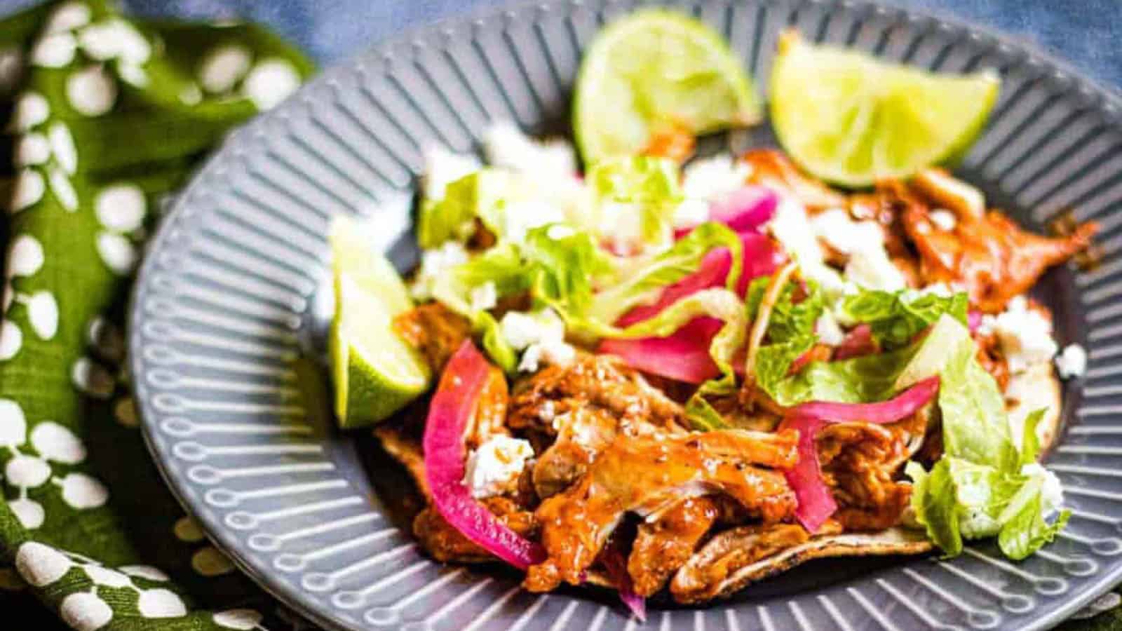 low angle shot of pollo pibil taco on a grey plate.